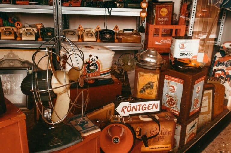 Oude elektrische apparaten en vintage items op een rommelige marktstand.