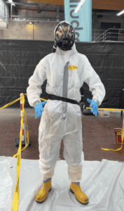 Person in protective asbestos removal equipment.