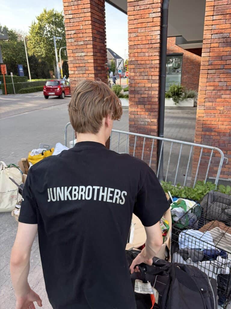 Medewerker van JunkBrothers draagt spullen naar buiten